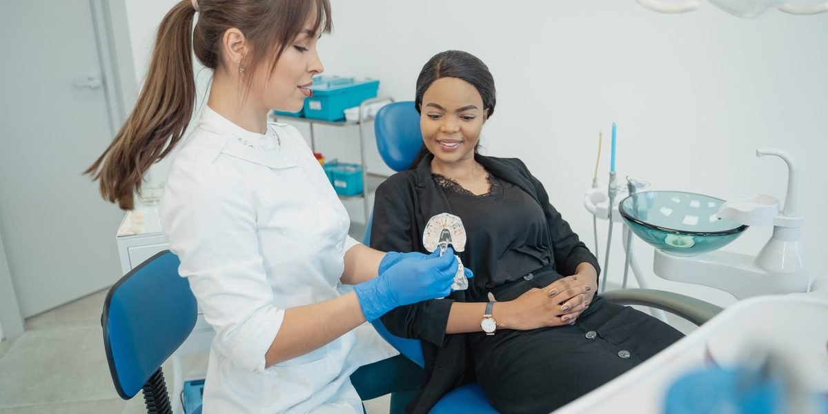 Dentist showing a patient a model of clear aligners at Enhance Dental in High Wycombe